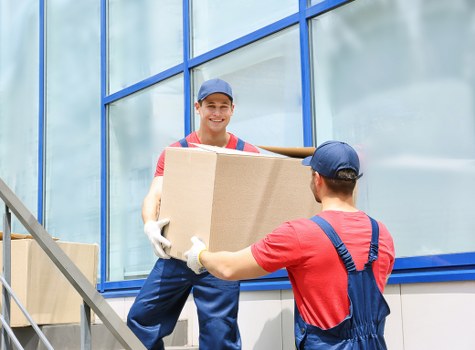 Moving crew carrying furniture through a home during a Colliers Wood removal